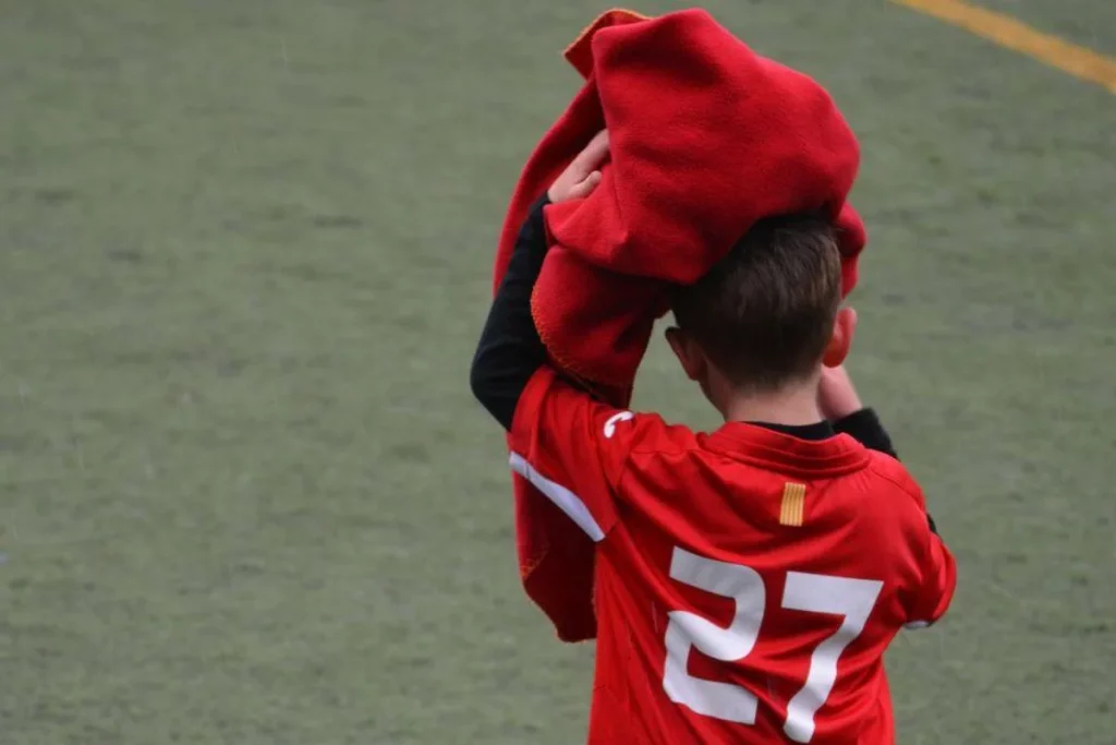 Boy quitting a football match in football kit